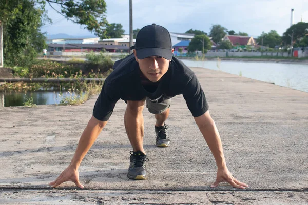 Formda ve kendine güvenen adam başlama pozisyonunda koşmaya hazır.