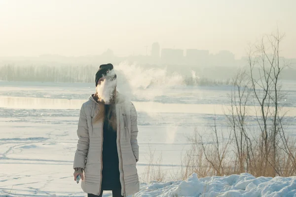 Lány a maszk füstöl egy elektronikus cigaretta — Stock Fotó