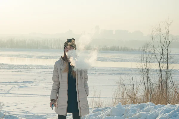 Κορίτσι στη μάσκα καπνίζει ένα ηλεκτρονικό τσιγάρο — Φωτογραφία Αρχείου