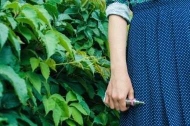 Elektronik sigara elinde tutan kız vape mod bush arka plan üzerinde