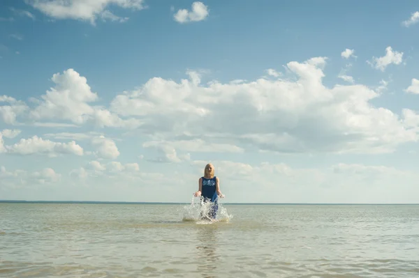Dziewczyna w sukience skoki w wodzie morskiej — Zdjęcie stockowe