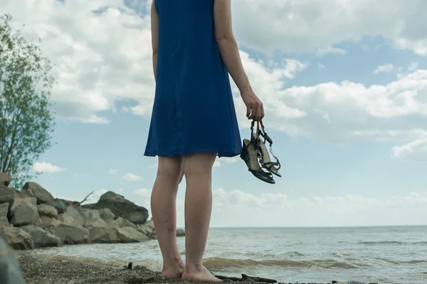 Pieds nus fille debout sur la plage et regarde dans la distance — Photo