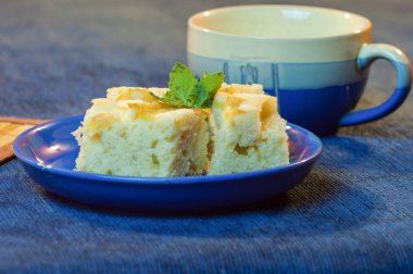 Bir bardak süt ile mavi tabakta lezzetli pasta