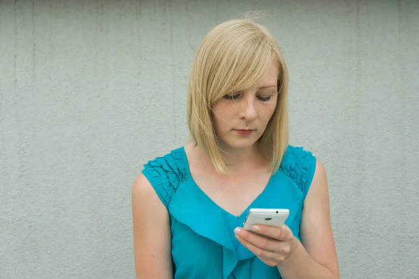 the girl with the phone on the street in the yard