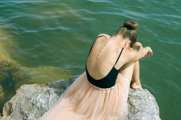 Dívka na břehu na skalách — Stock fotografie