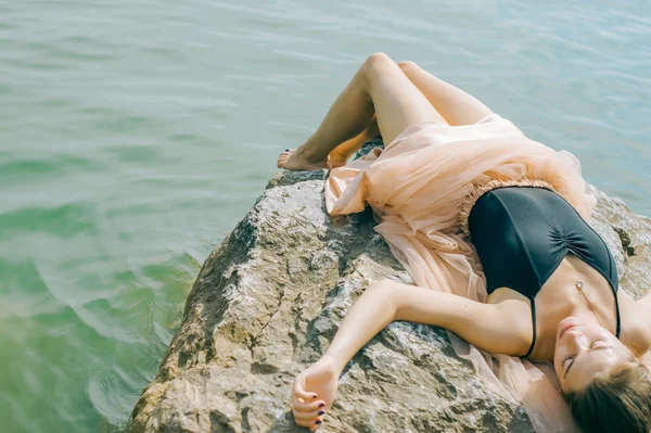 Chica en la orilla en las rocas — Foto de Stock