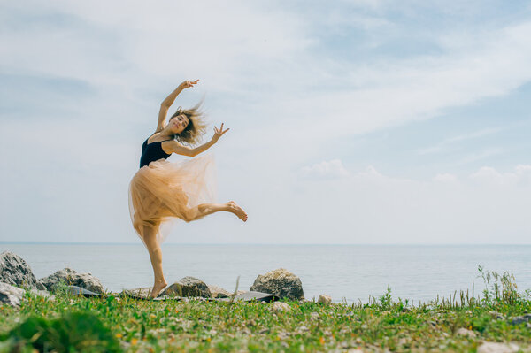 young woman is engaged in meditation, stretching, yoga on the beach background