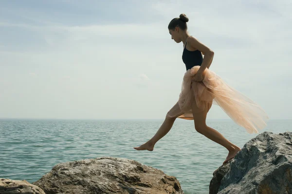 在岸边的岩石上跳舞的女孩 — 图库照片