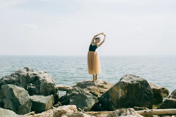 Tánc a sziklák, a parton a lány — Stock Fotó