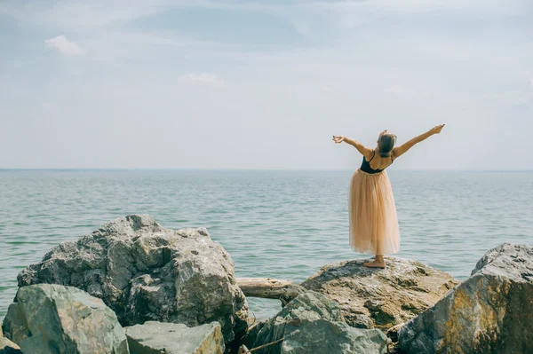Chica en la orilla en las rocas — Foto de Stock