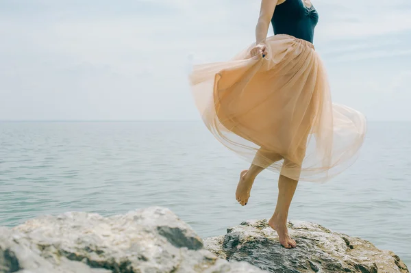 Dziewczyna taniec na skały na brzegu — Zdjęcie stockowe