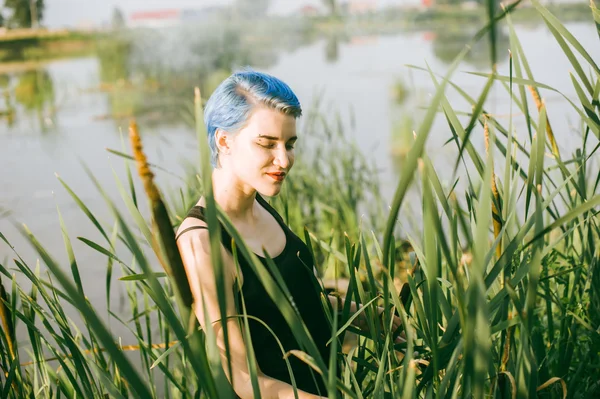 Joven hermosa chica con pelo azul se ve mirada depredador juncos — Foto de Stock