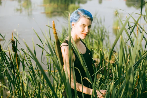 Jovem menina bonita com cabelo azul olha olhar olhar predador junco arbustos — Fotografia de Stock