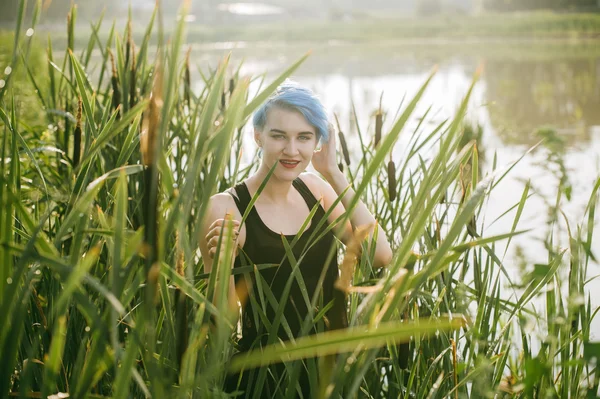 Joven hermosa chica con pelo azul se ve mirada depredador juncos — Foto de Stock