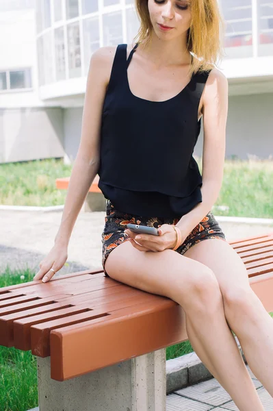 Молодая красивая девушка пользуется смартфоном — стоковое фото