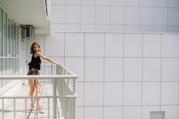 Schönes schlankes Mädchen in kurzen Hosen und T-Shirt, das auf Bolkone steht und in die Ferne blickt — Stockfoto