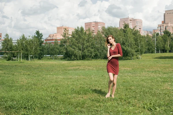 Menina em uma pose contra o pano de fundo da cidade — Fotografia de Stock