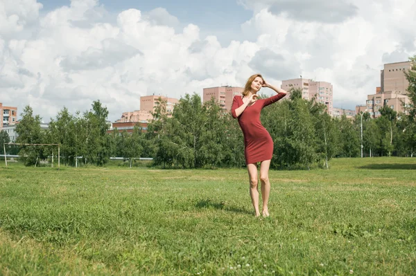 Menina em uma pose contra o pano de fundo da cidade — Fotografia de Stock