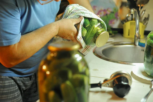 İnsanlar mutfakta hazırlanıyorlar. Asitleme salatalık, Tuzlama kış hazırlığı.