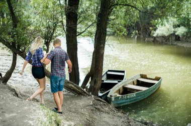 aşık adam ve kız zaman harcamak tekneler arka plan nehir kıyısında yürürken
