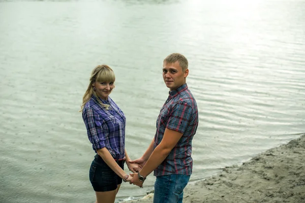 Aşık adam ve kız zaman harcamak tekneler arka plan nehir kıyısında yürürken — Stok fotoğraf