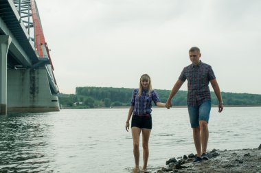 sevgi, adam ve nehrin kıyısı yürüyen kadın genç Çift