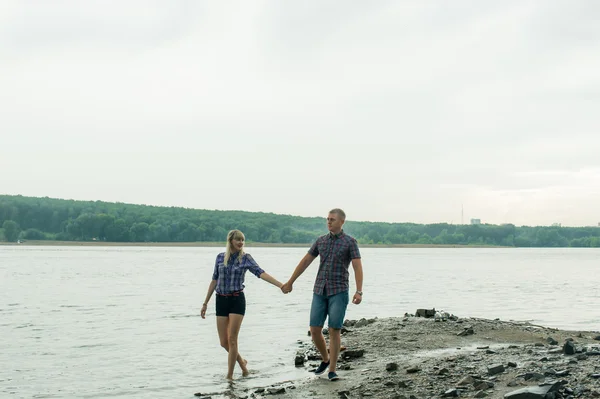 Νεαρό ζευγάρι στην αγάπη, άνδρας και γυναίκα το περπάτημα κατά μήκος της όχθης του ποταμού — Φωτογραφία Αρχείου