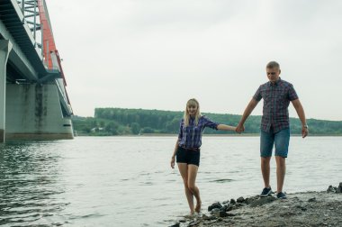 sevgi, adam ve nehrin kıyısı yürüyen kadın genç Çift