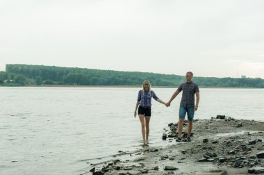 sevgi, adam ve nehrin kıyısı yürüyen kadın genç Çift