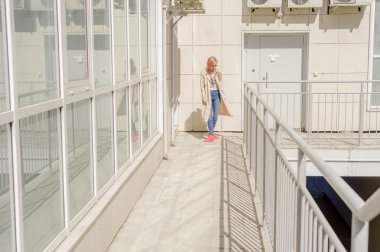 Kız güneş gözlüğü ve bir sırt çantası, yavaş yavaş avlu yürür