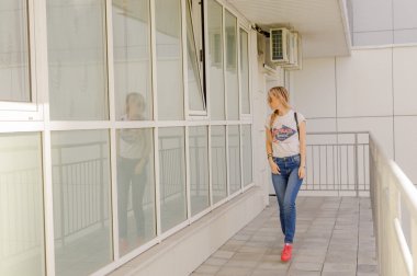 Kız güneş gözlüğü ve bir sırt çantası, yavaş yavaş avlu yürür