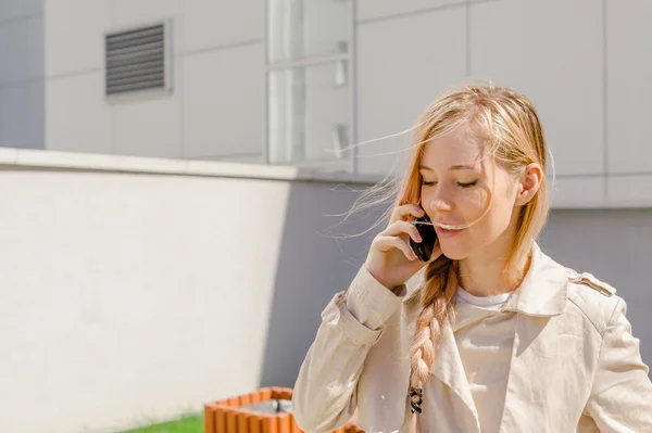 Dziewczyna rozmawia telefon komórkowy na ulicy — Zdjęcie stockowe