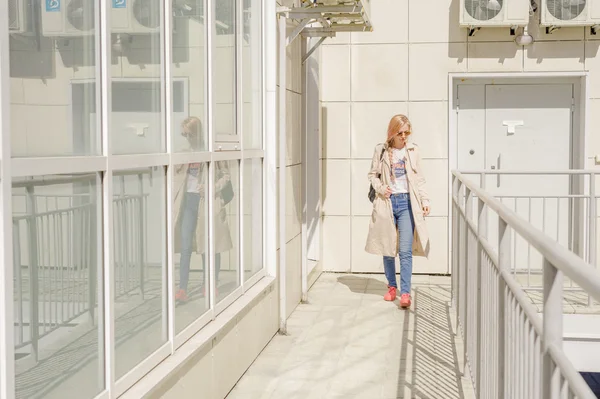 Mädchen mit Sonnenbrille und Rucksack läuft langsam über den Hof — Stockfoto