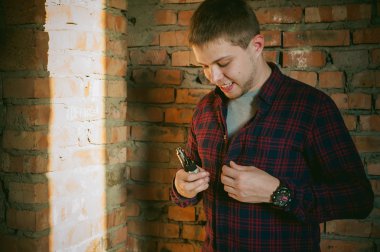 adam bir ekose gömlek ve pantolon ishal vape suyu elektronik sigara. O mekanik bir mod ile BKİ tutar. 