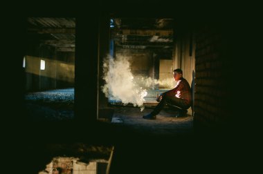 adam bir ekose gömlek ve kot pantolon, duman ve buharlaşma Buhar mekanik bir aygıt üfleme elektronik sigara, Sigara içiyor. moda hobi, Sigara, gliserin bulutlar için alternatif