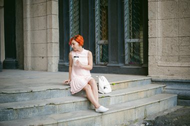 Bir fincan kahve içer