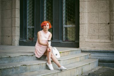 Bir fincan kahve içer