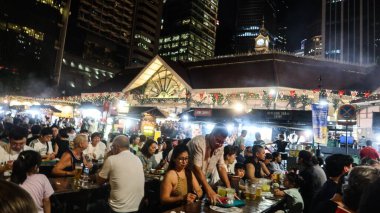 Lau Pa Sat, Raffles Quay, Singapur - 14 Ağustos 2025: Viktorya döneminden kalma yeniden inşa edilmiş Hawker Center 'ın önünde şiş yiyen ve şarap içen insanlarla dolu açık hava pazarı. 