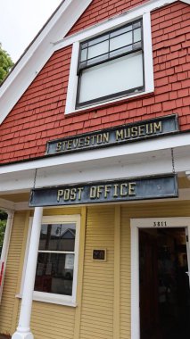 Steveston Müzesi ve Postane, Steveston, Richmond, British Columbia, Kanada - 1 Ekim 2025: sergi ve postane için turuncu ve sarı ev
