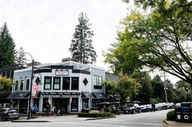 Reid Blok binası, Fort Langley, British Columbia, Kanada - 8 Ekim 2025: Dışarıda bir sürü insanın oturduğu bir kafe Arabaların geçtiği ve ağaçların olduğu bir kafe