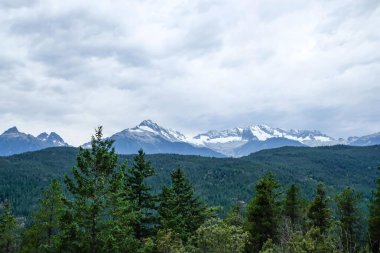 Tantalus Gözcüleri, Squamish, British Columbia, Kanada 'dan alındı. Orman ve ağaçlarla dolu bulutlu bir günde.