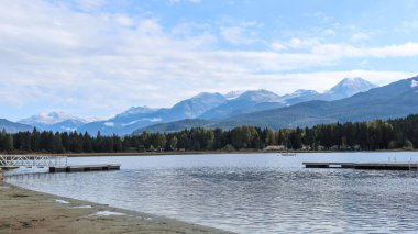 Gökkuşağı Parkı, Whistler, British Columbia, Kanada: Mavi gökyüzü ve ağaçların yansımasıyla güzel bir hava gününde Gökkuşağı Gölü boyunca yol ve park