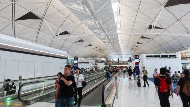 Hong Kong Uluslararası Havalimanı, Chek Lap Kok, Hong Kong - 1 Ekim 2025: Geometrik bal peteği tavanlı turistler havaalanı terminali boyunca yürüyorlar