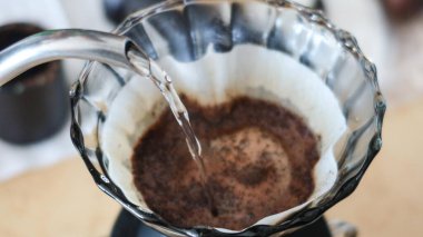 Filtre kağıdının üzerine şeffaf bir dökümle kahve dökmek için sıcak su eklemeyi unutma.