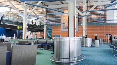 Vancouver Havaalanı, British Columbia, Kanada - 11 Ekim 2025: Havaalanının kalkış salonundaki oturma alanında oturan birçok turist