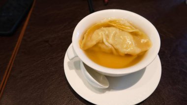 Superior Brothda buğulanmış deniz mahsulleri hamur köftesi karidesle dolu büyük bir hamur köftesi ve temiz bir çorbanın içinde fotokopi alanı olan beyaz bir kasede.