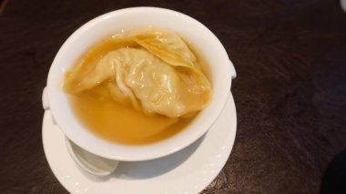 Superior Brothda buğulanmış deniz mahsulleri hamur köftesi karidesle dolu büyük bir hamur köftesi ve temiz bir çorbanın içinde fotokopi alanı olan beyaz bir kasede.