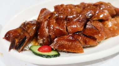 Çin usulü ızgara kavurma, çıtır derili ve fotokopi alanlı klasik siu mei (kızarmış et) ve yanında da salatalık dilimi.