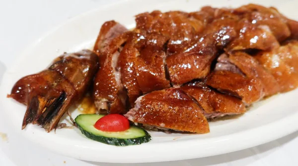 Çin usulü ızgara kavurma, çıtır derili ve fotokopi alanlı klasik siu mei (kızarmış et) ve yanında da salatalık dilimi.