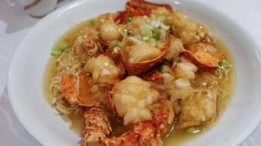 Çin usulü Hong Kong usulü haşlanmış ıstakoz, beyaz tabakta soslu e-fu şehriye ve kopyalama alanı.